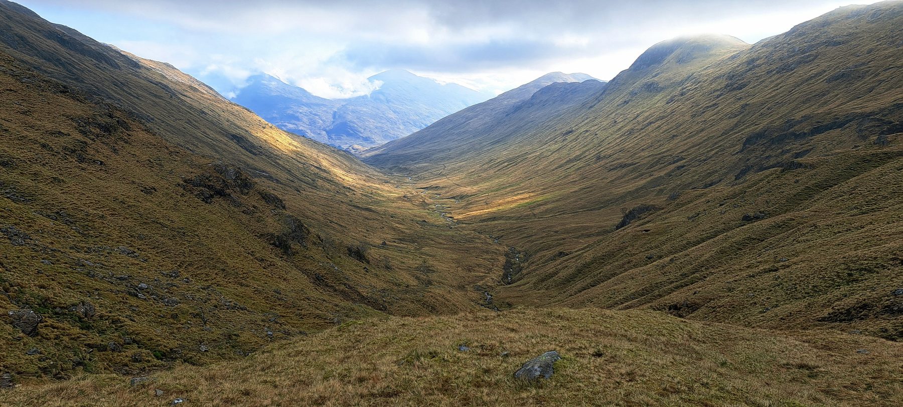 Looking down a deep Highland valley with mountains rising on both sides, on the Cape Wrath Trail above Corryhully.