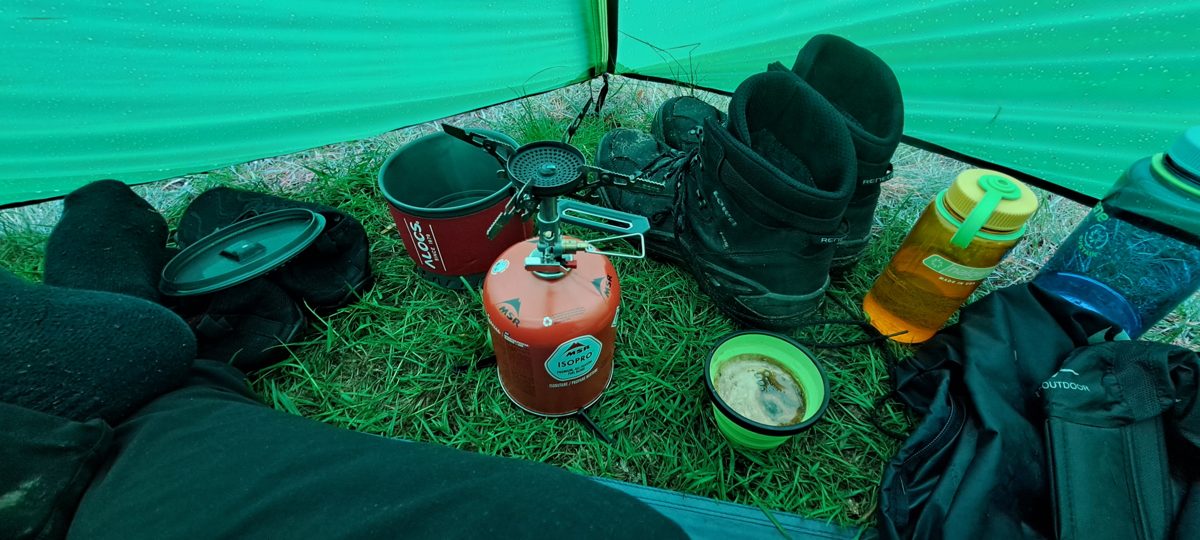 Evening at camp with a stove and mugs in the tent vestibule