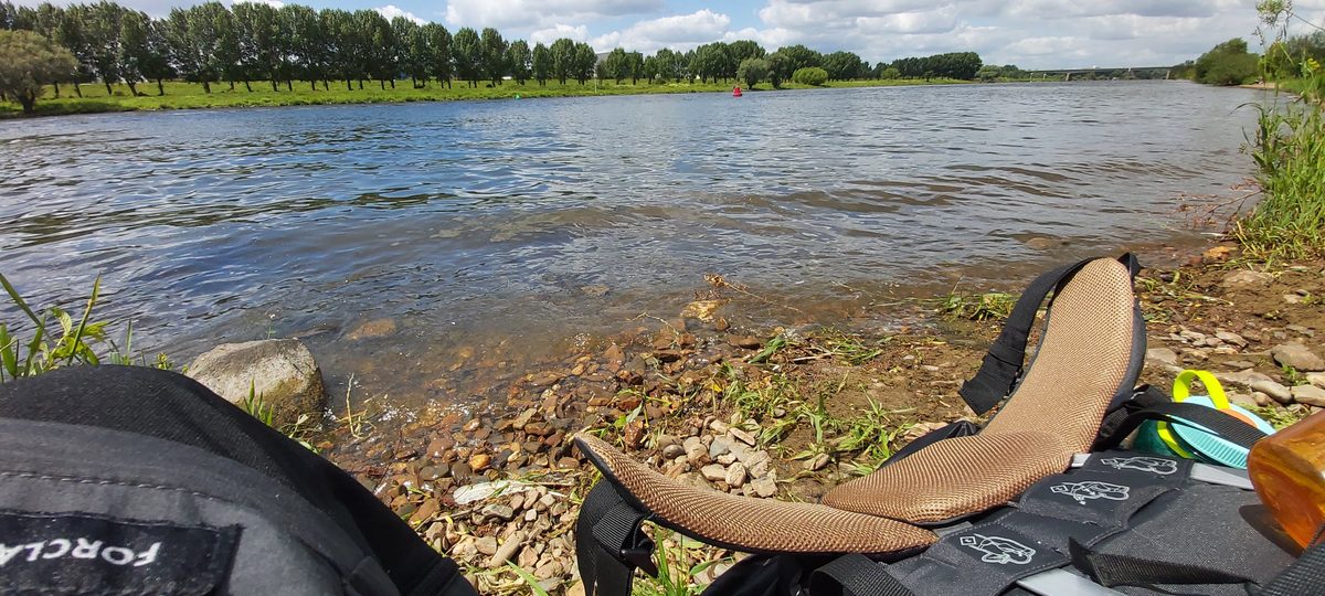 Resting for lunch on the pebbled bank of the river Maas on the Pieterpad