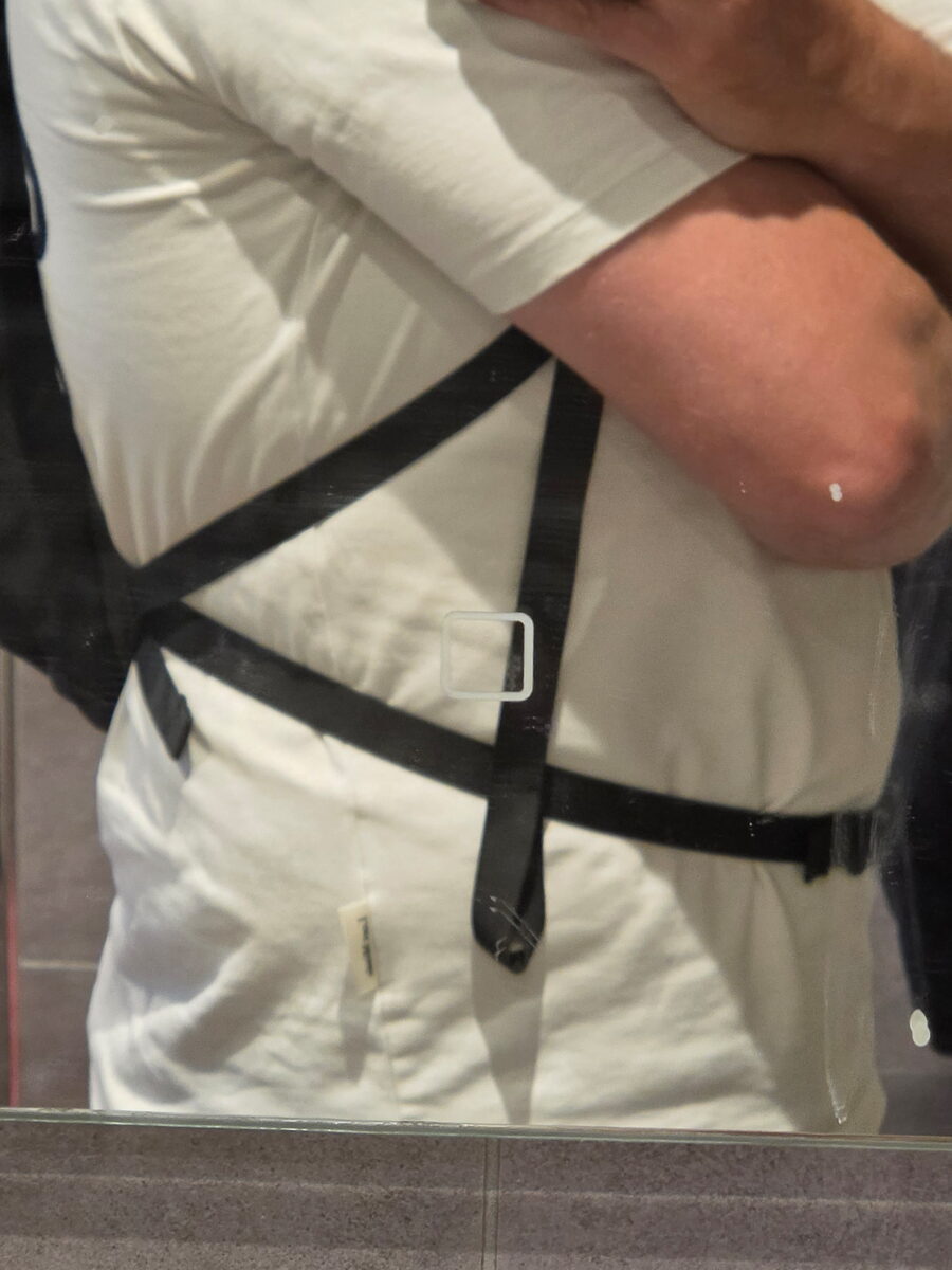 The cross-style hip belt of the WATERFLY 20L worn over a white T-shirt